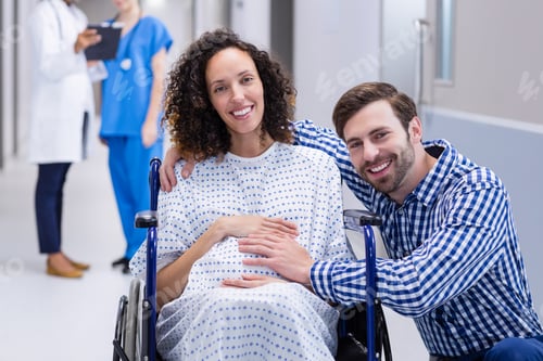 Preview: Portrait of man touching pregnant woman belly in corridor