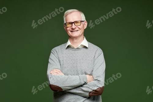 Preview: Happy senior male with his arms crossed by chest looking at camera
