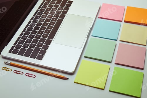 Preview: laptop, set of paper stickers, pencil and paper clips on white tabletop