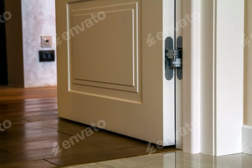 Preview: Modern house interior detail with wooden parquet floor and white door.