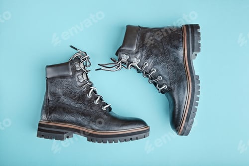 Preview: Pair of black genuine leather boots. Blue background
