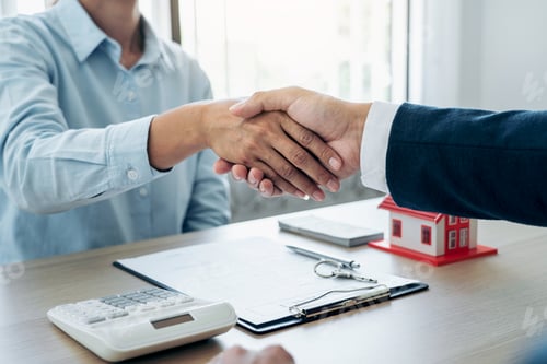 Preview: Estate agent and customers shake hands together celebrating the