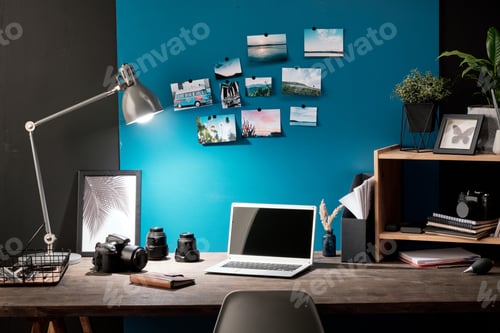 Preview: Workplace of photographer with photos of nature on blue board in front of table