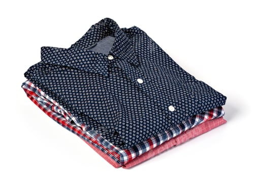 Preview: Stack of Folded Shirts on a White Background