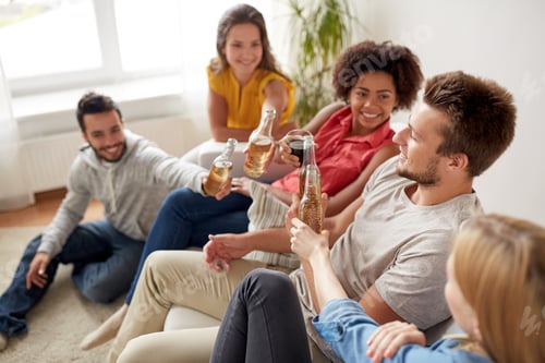 Preview: group of happy friends with drinks talking at home