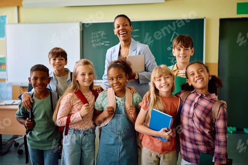 Preview: Group of happy elementary school children with their teacher looking at camera.