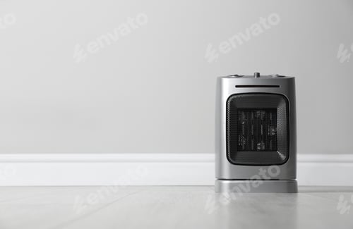 Preview: Modern electric fan heater on floor in room, space for text