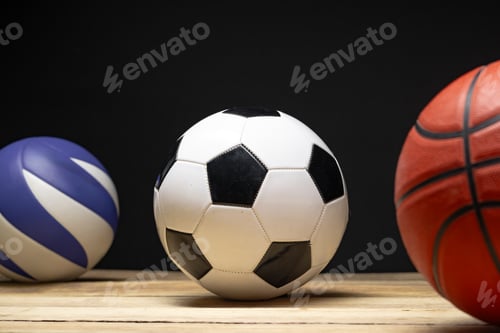 Preview: Set of various sport balls on wooden floor on black background