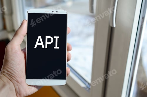 Vista previa: Una persona ve una inscripción blanca en la pantalla negra de un teléfono inteligente que sostiene en su mano.
API