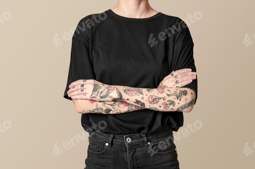 Preview: Tattooed Person with Crossed Arms Wearing Black
