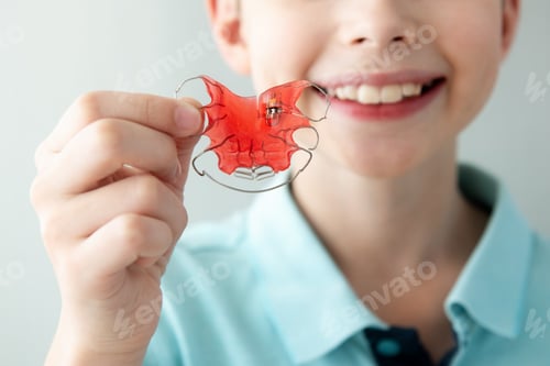Preview: Teeth Dental Plate for Children. Child Holding Red Orthodontic Braces Retainer Fixer for Aligning