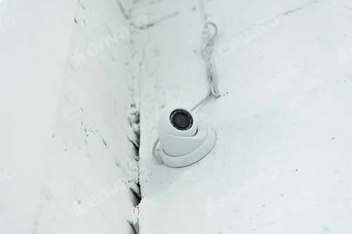 Preview: low angle view of supervision camera on white wall