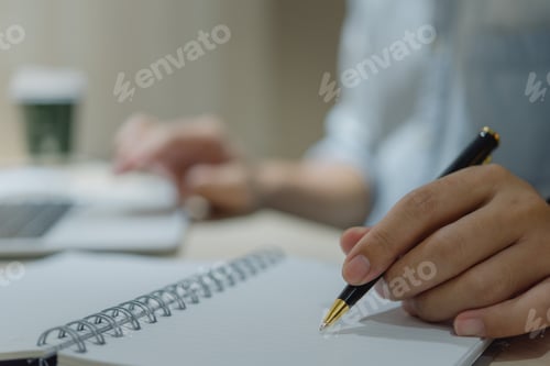 Preview: man hands with pen writing on notebook in the office.learning, education