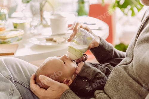 Preview: Father bottle-feeding his newborn baby boy