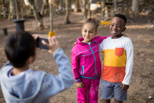 Preview: Boy taking picture of his friends with mobile phone