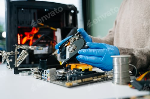 Preview: Technician repairing inside of hard disk drive by screwdriver. the concept of data, hardware,