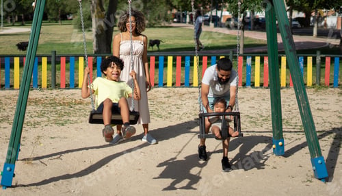 Preview: Latin family with a child and a baby enjoying a sunny day on the swings of a playground