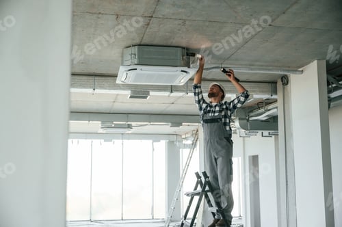 Preview: Setting the ventilation system. Repairman in uniform is in the unfinished building