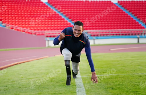 Preview: Asian para-athletes with prosthetic blades sprint on a running track at stadium.