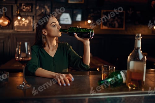 Preview: Unhappy woman drinks alcohol at the counter in bar