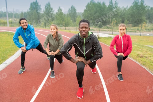 Preview: Healthy young intercultural friends in activewear exercising on race tracks