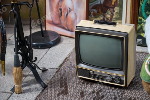 Vista previa: Retro television. Old tube portable TV with handle on flea market outdoors