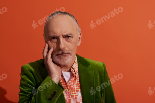 Preview: fashion and age, portrait of grey haired, bearded, thoughtful man touching face and looking