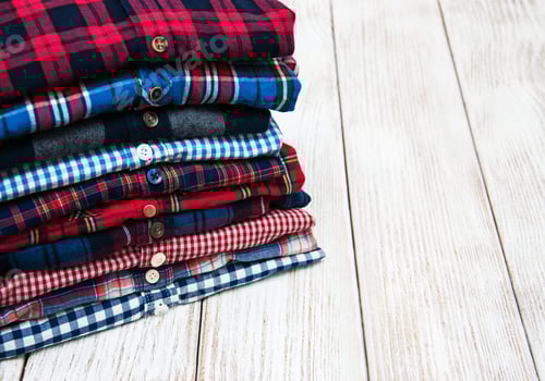 Preview: Neatly Folded Flannel Shirts on Wooden Table