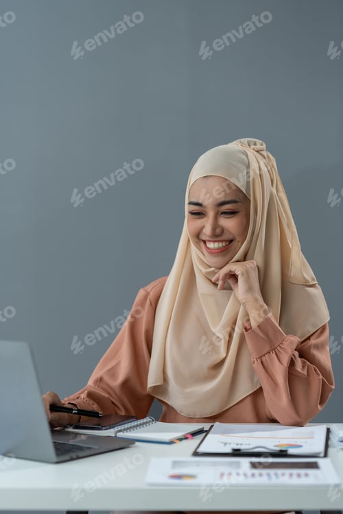 Preview: Motivated muslim businesswoman wearing hijab working on real estate project analyzing documents data