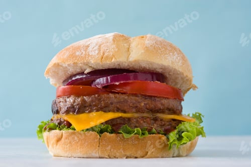 Preview: Delicious double burger with lettuce, tomato, onion and cheese on light blue background