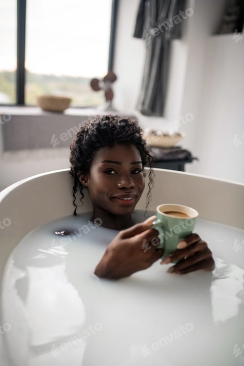 Preview: Woman drinking morning coffee while chilling in bath