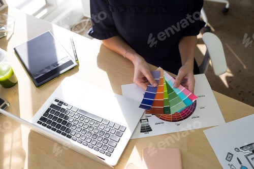 Preview: Female executives holding color shade swatch at her desk