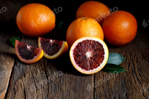 Preview: Sliced Sicilian Blood oranges fruits over old dark wooden background. Top view.