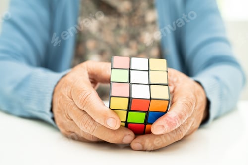 Preview: Alzheimer disease AD, Asian elderly woman patient playing Rubik cube game to practice brain