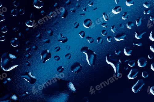 Preview: Water drops on window glass. Rain drops on dark trendy blue background