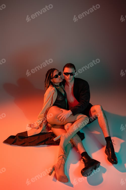 Preview: high angle view of trendy man in black blazer and shorts near african american woman in dark