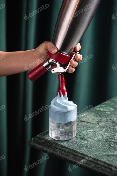 Preview: Cocktail with blue foam being poured from siphon