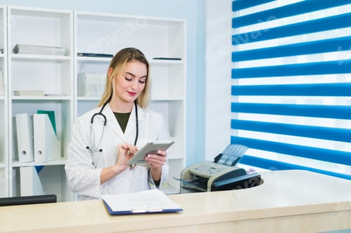 Preview: Female doctor using tablet at desk in office