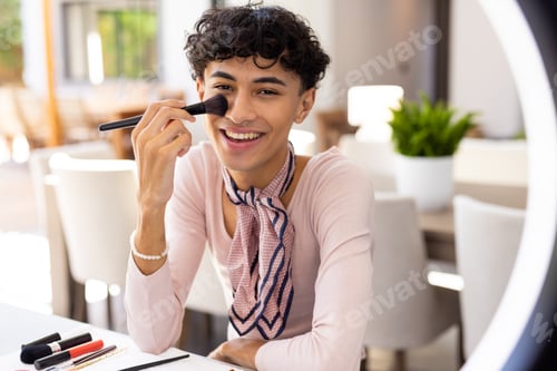 Preview: Applying makeup with brush, transgender woman smiling and sitting at table