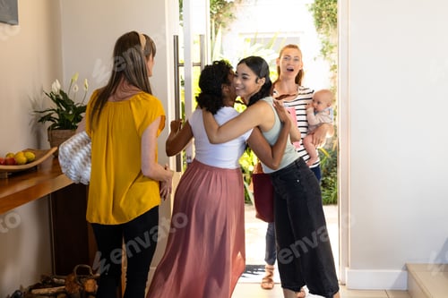 Preview: Friends greeting each other warmly at home, sharing joyful hugs and smiles