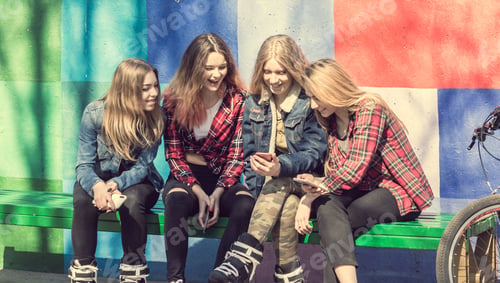 Preview: Cute girls sitting on the bench in the park and laughing