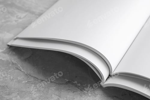 Preview: Blank open books on light grey marble background, closeup. Mock up for design