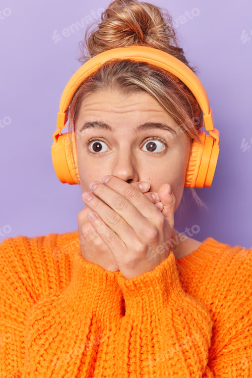 Preview: Frightened fearful young woman covers mouth with hands tries to be mute stares with popped eyes list