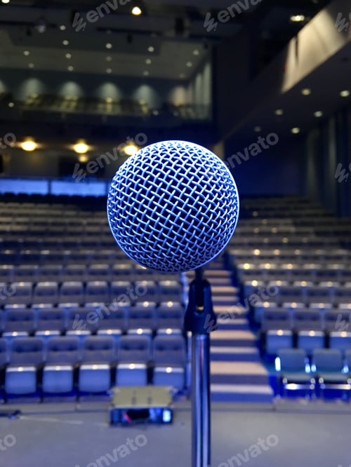 Preview: Close-up of a microphone that is clipped to a microphone stand in an empty theatre.