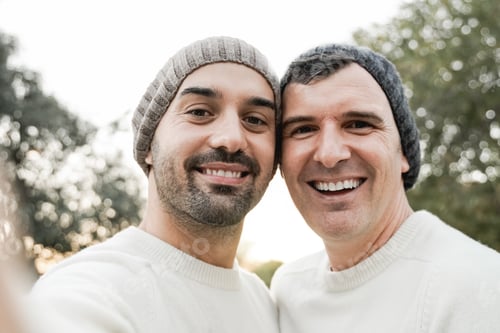 Preview: LGBT gay men couple having fun doing selfie outdoor at city park - Focus on left man face