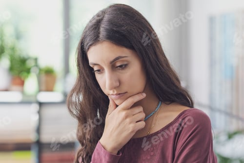 Vista previa: Pensive woman with hand on chin
