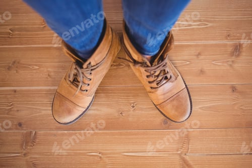 Preview: High angle view of woman wearing boots on wooden planks background