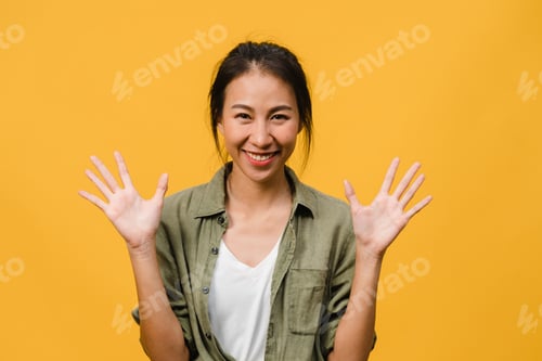 Preview: Young Asia lady with positive expression, smile broadly on yellow background.