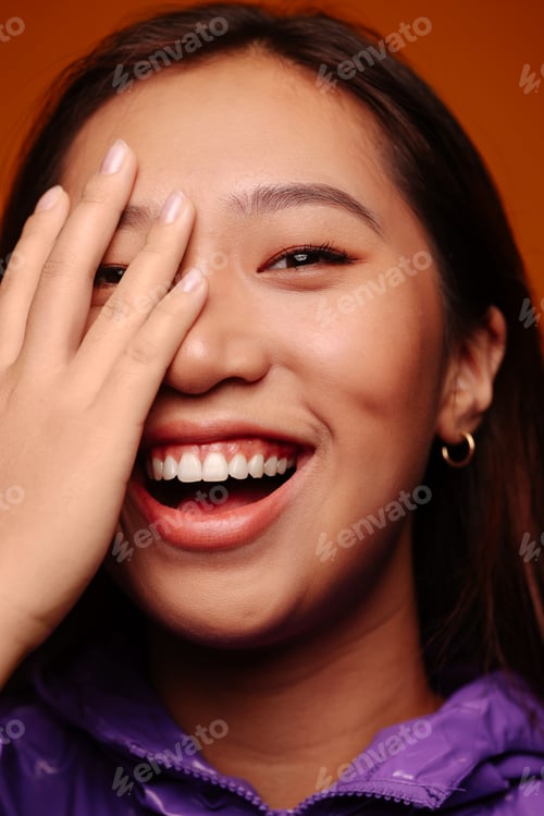 Preview: Young Chinese laughing on yellow background.