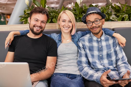 Preview: Cheerful multiracial colleagues sitting close and smiling at camera